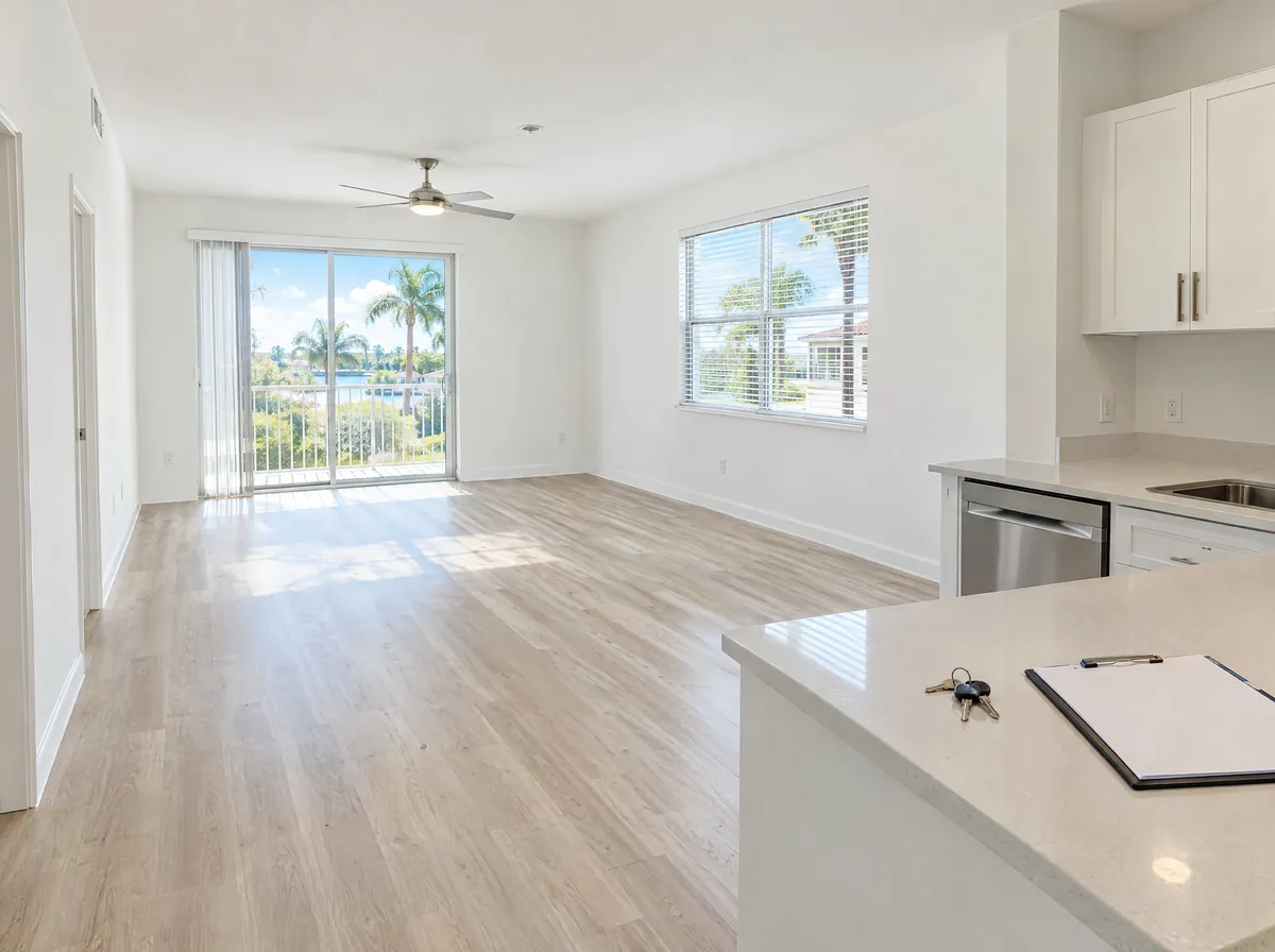 An empty, freshly painted and cleaned apartment with keys and a clipboard on the kitchen counter